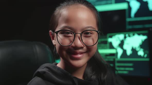 Asian Young Girl Hacker Hacking With Multiple Computer Screens And Smiling To Camera In Dark Room alt