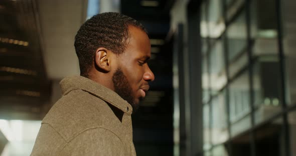A Young AfricanAmerican Man is Standing Sideways to the Camera and Talking alt