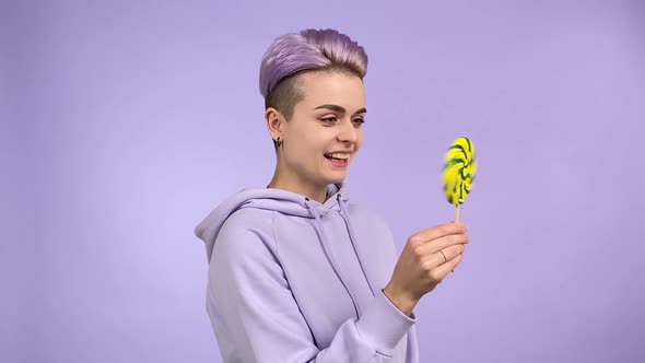 Young Person Holding Lollipop Dropping It Expressing Disappointment alt