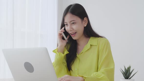 Young asian business woman working form home office and call phone for success at home.
