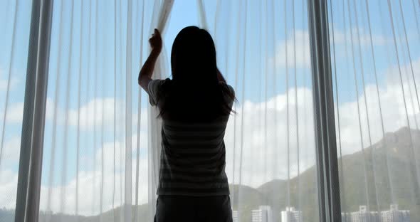 Woman stretching hand and open the curtain at home  alt