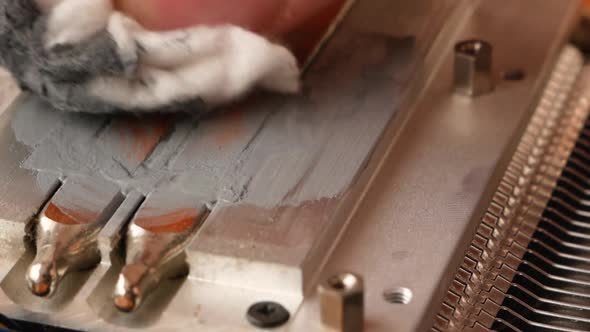 Close-up of the process of replacing thermal paste on a PC processor cooling cooler. alt