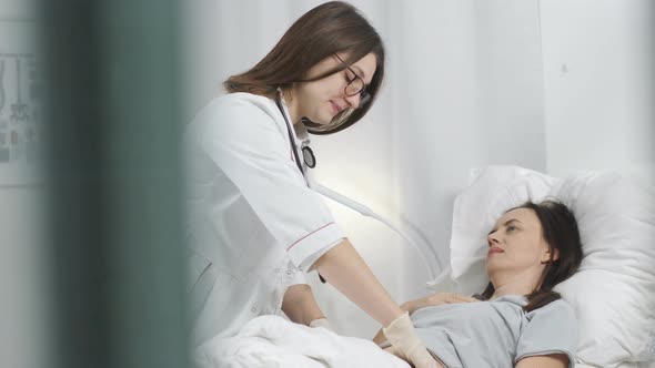Woman Doctor with Gloves Palpated the Abdomen of the Patient in the Hospital alt