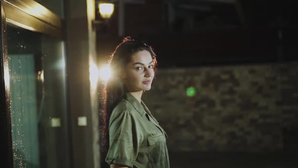 Happy Girl Smiling to Camera and Poses with Long Hair After Rain at Night alt