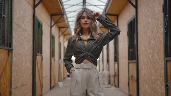 Confident Fashionable Model Rumpling Hair in Stable alt