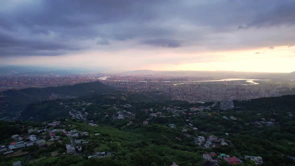 Overlooking Taipei, Taiwan from a mountain during dramatic cloudy sunset - Drone Forward push alt