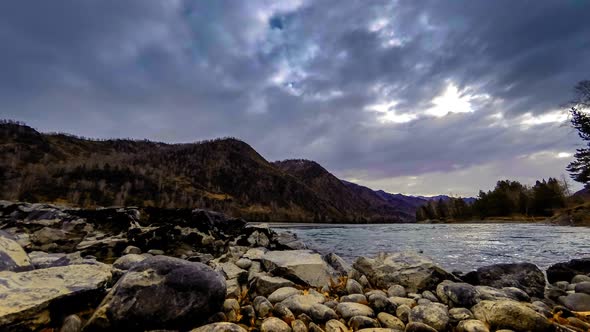 Time Lapse Shot of a River Near Mountain Forest. Huge Rocks and Fast Clouds alt