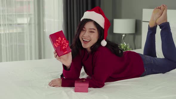 happy woman with Christmas gift box on a bed