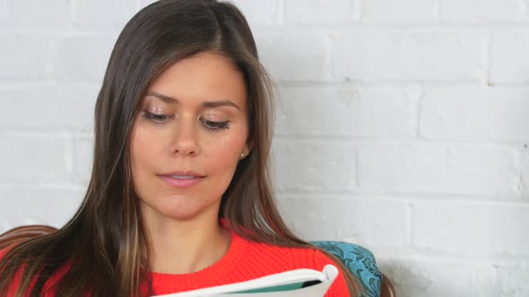 Attractive Young Female In Orange Sweater Sitting While Writing In Her Journal 3 alt