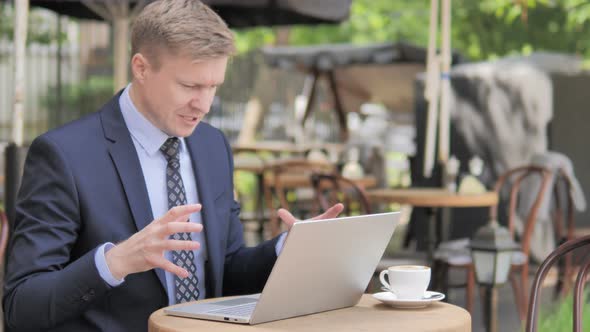 Angry Businessman Working on Laptop in Frustration alt