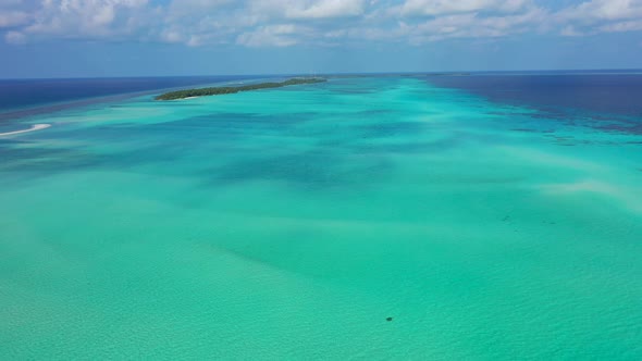 Daytime birds eye travel shot of a white sandy paradise beach and aqua blue water background in vibr alt