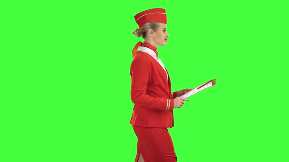 Woman Steps Along with a Red Folder in Her Hands. Green Screen. Side View alt