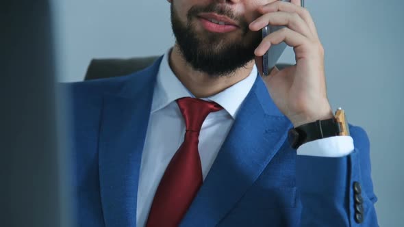 Businessman Talking On Mobile Phone In Office