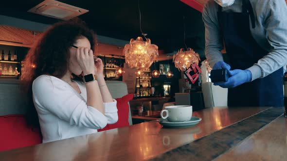 A Lady is Using Contactless Payment in a Cafe During Pandemic alt