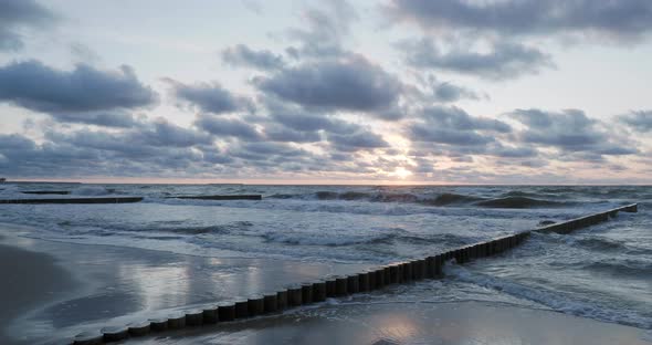 Breakwater of Larch Logs. Strengthening the Seashore To Keep the Sand on the Beach. Gorgeous Sunset alt