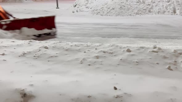 Snow Plow Tractor Removes Snow From the Roadway in the Parking Lot While There are No Cars at Night alt