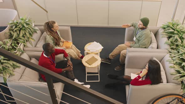 Young Businesspeople in Armchairs Chatting alt