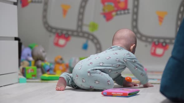 A Crawling Funny Baby Indoors at Home Play with Toys