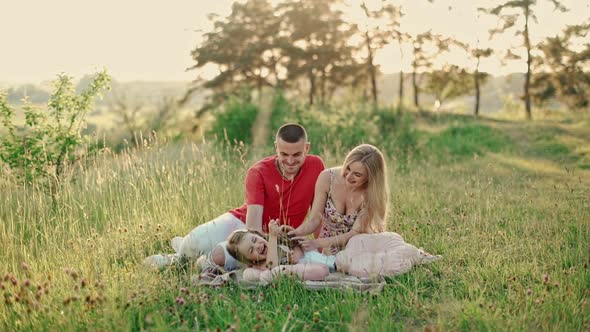Young mom and dad with cute little daughter having fun outdoors in the woods.  alt