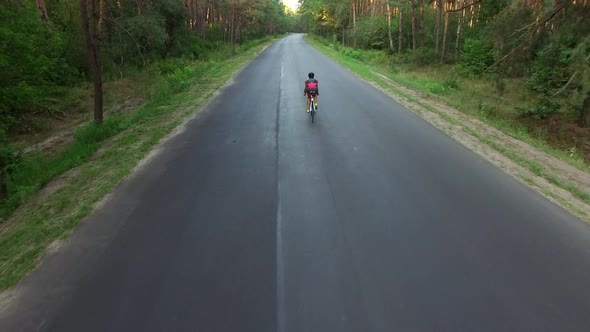 Woman Is Cycling on Country Road During Triathlon Training