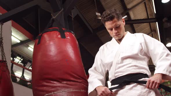 Man in black belt standing in fitness studio alt