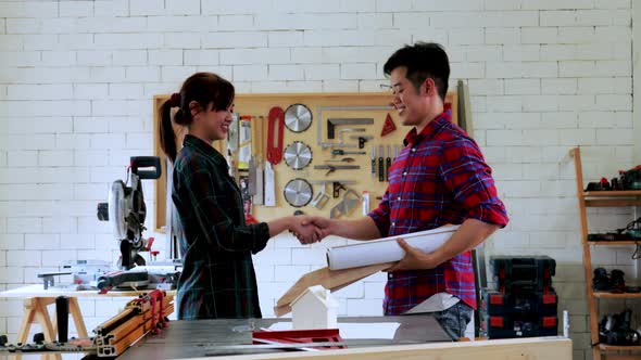 Couple architect take a handshake in workshop for new project, small business
