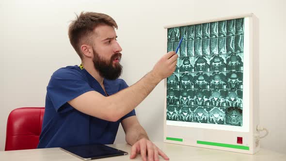 Physiotherapist Shows Patient an Xray Image of Skeleton of Bones alt