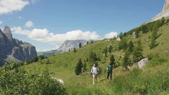 Two people hiking in mountain landscape, Alta Badia, Italy