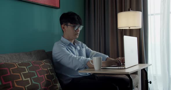 Young Attractive Asian Vietnam Man Busy Work Computer or Smart Tablet on Table Desk at Home in alt