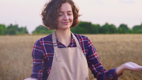 Portrait Of Happy And Smiling Farmer In Apron On Wheat Field. Girl Having Fun With Flour, Organic alt