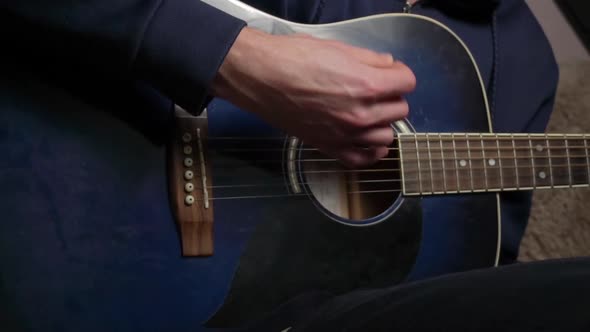 Man Plays a Pick on a Modern Guitar in the Dark Slow Mo alt