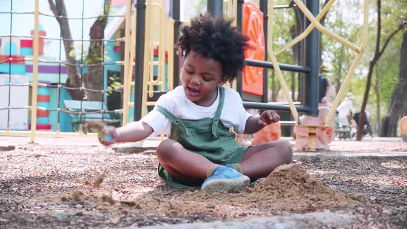 African American boy playing sand in playground