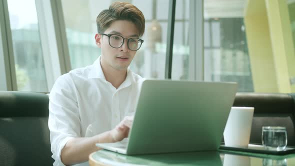 Smart attractive positive asian business male wearing glasses work remote new normal lifestyle