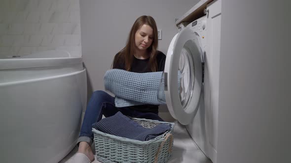 Woman Opens Door of Washing Machine Puts in Dirty Clothes and Takes Out Clothes
