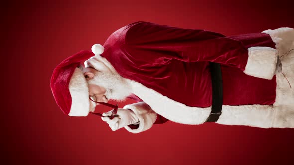 Santa Claus Putting on Trendy Sunglasses alt