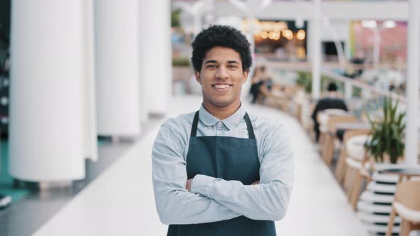 Confident African 30s Restaurant Worker Biracial Guy Strong Position Standing Indoors Barman Seller alt