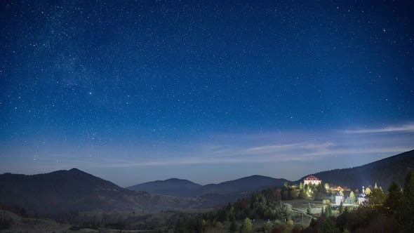 Starry Sky with White Clouds Floating Above Town in Highland alt