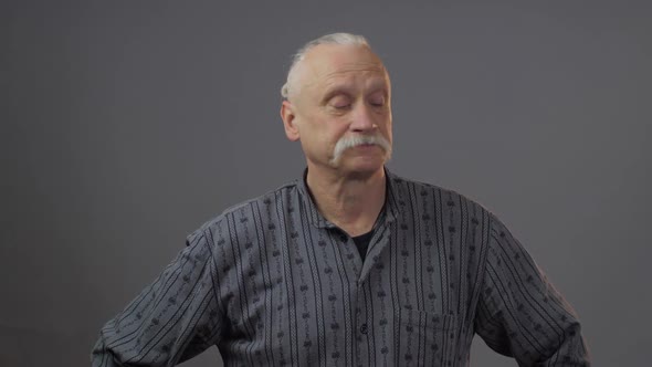 Arrogant Senior Grey Haired Man in Dark Shirt Looks Down alt