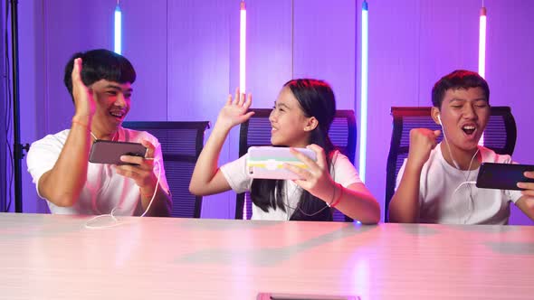 Gamers Playing In Competitive Video Games On A Cyber Games Tournament By Mobile Phone And Celebrate alt