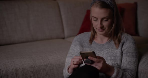 Woman Browsing Social Media on Smartphone at Home alt