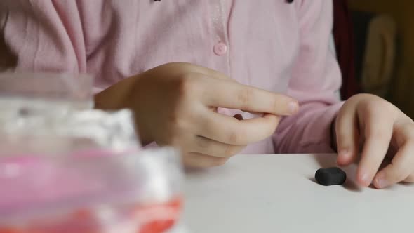 Closeup of the Hands of a Teenager Girl are Molded From Plasticine on the Table alt