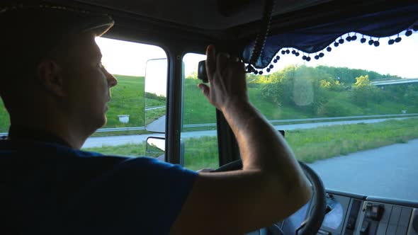 Close Up of Lorry Driver Riding Through Countryside and Attentively Watching Road at Sunset Time
