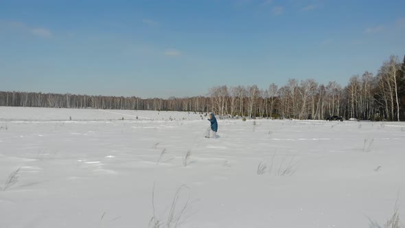 Woman Walks Through Snow Field alt