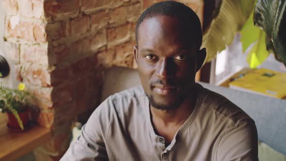Afro-American Man Smiling and Posing for Camera in Cafe alt