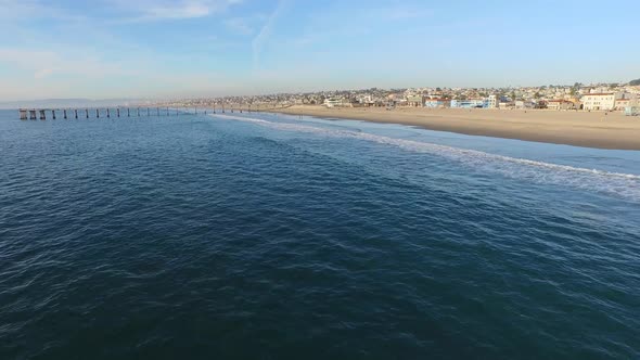 Aerial shot of a scenic beach city and ocean at sunset. alt