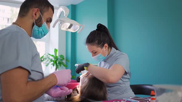 Two dentist doctors in medical masks, a man and a woman in a dental office. Dentistry. alt