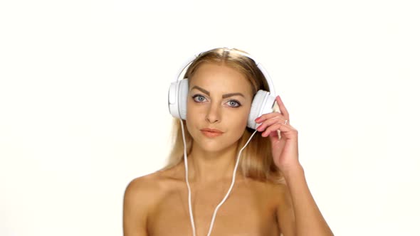 Sexy Woman in White Shirt Listening and Dances for the Music Using Headphones alt