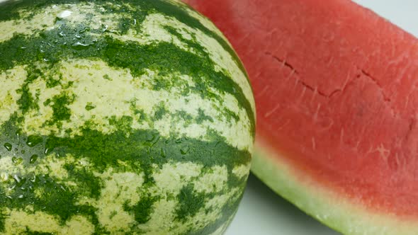 Watermelon Covered In Drops Of Water And A Delicious Slice On White Surface