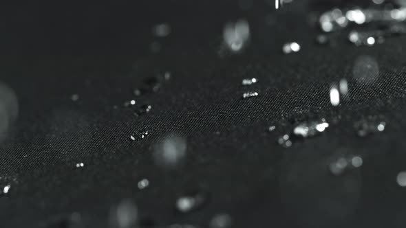 Super Slow Motion Shot of Water Droplets Splashing on Waterproof Cloth at 1000Fps. alt