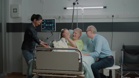 Little Girl Hugging Ill Grandma at Family Visit in Hospital Ward alt